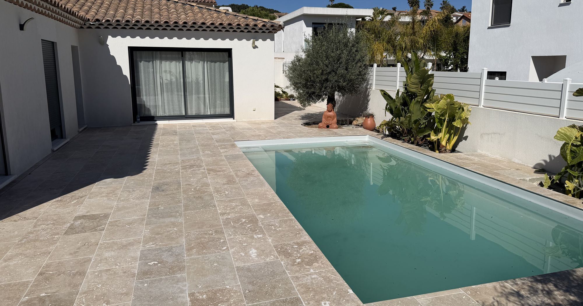 Plage de piscine en travertin autour d'une piscine